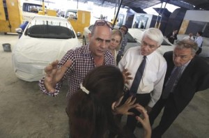 Donohue at the car-repair cooperative. To his left is manager Marcelo Gonzalez, and on far right is Marcel Smits of the Cargill Corporation.