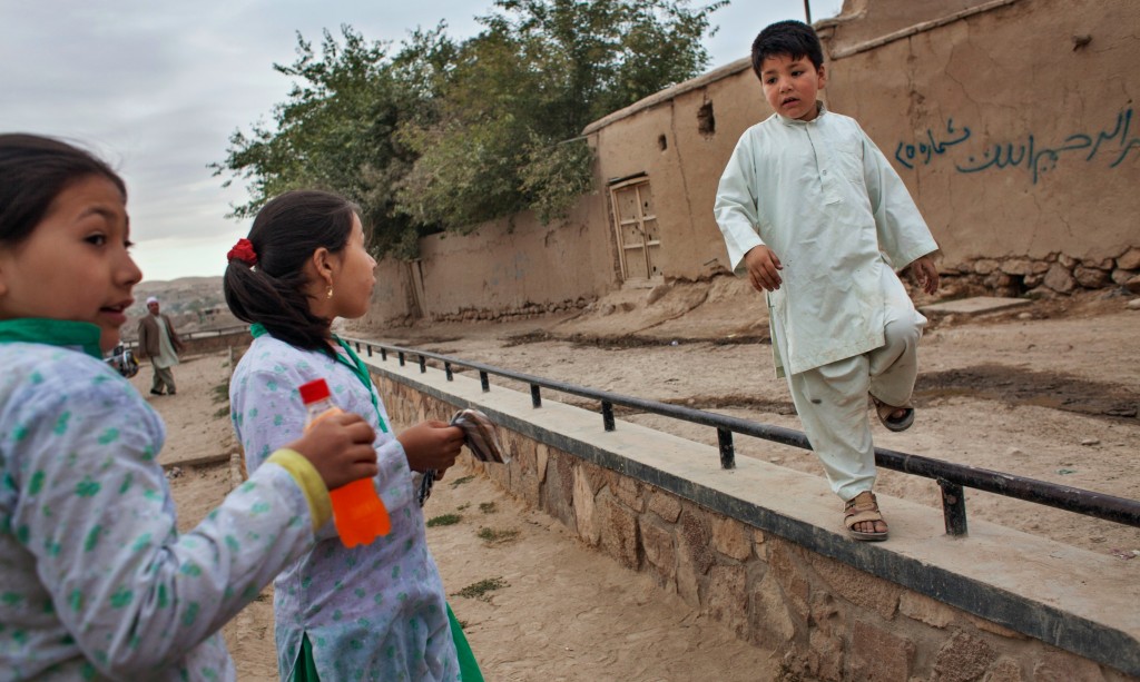 Mehran, age 7, plays with her twin 11-year-old sisters outside their home in Badghis province, Afghanistan, in September 2010.