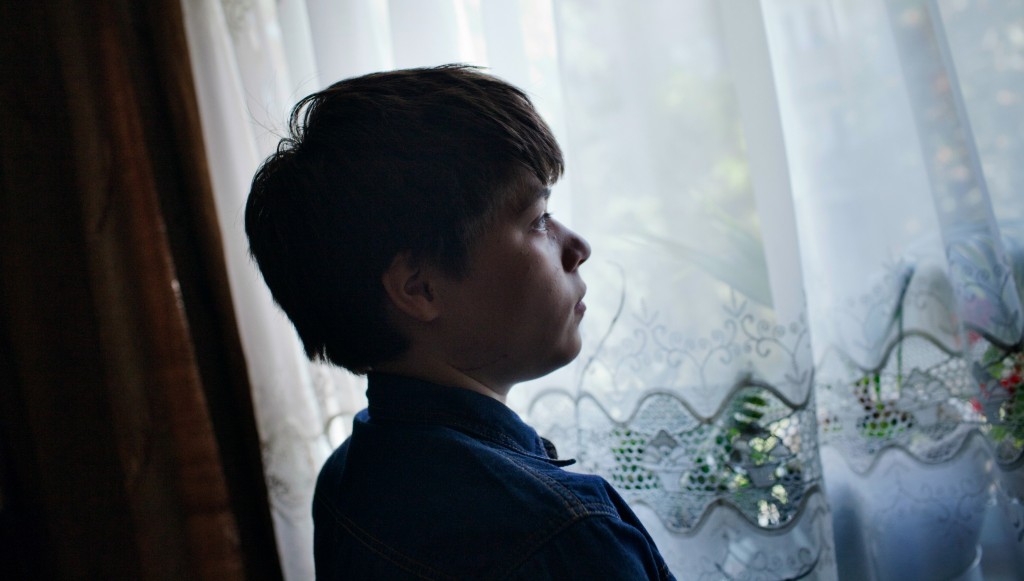 Zahra gazes out a window of her family ’s Kabul home.