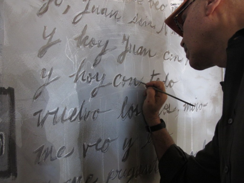 Andy Shallal paints the words to the poem “Tengo” by Nicolás Guillén. (David Montgomery/The Washington Post)