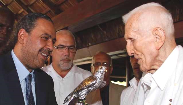 The prince presents a statuette to the president of the Cuban Olympic Committee, José Ramón Fernández. Behind the prince is Cuban Sports Minister Antonio Becali Garrido.